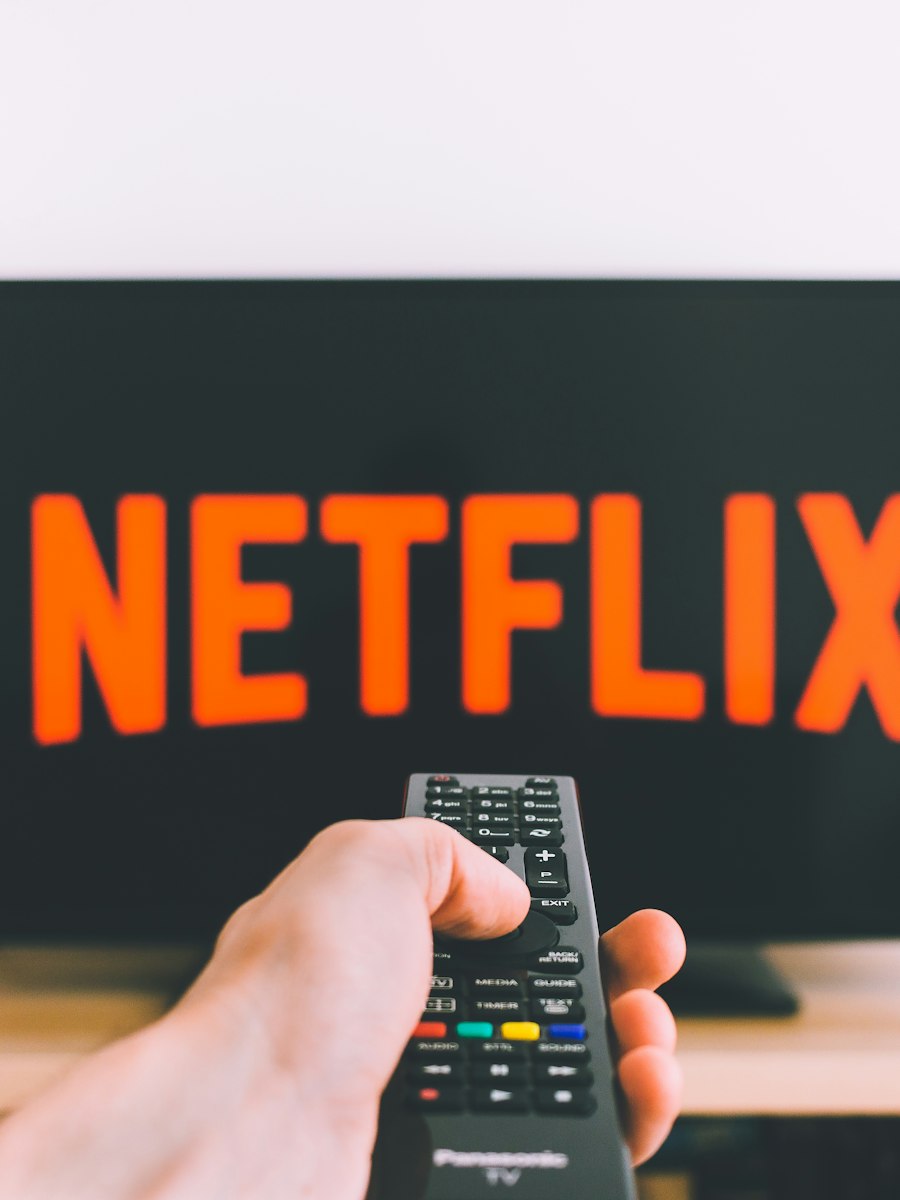 A remote pointed at a TV showing Netflix